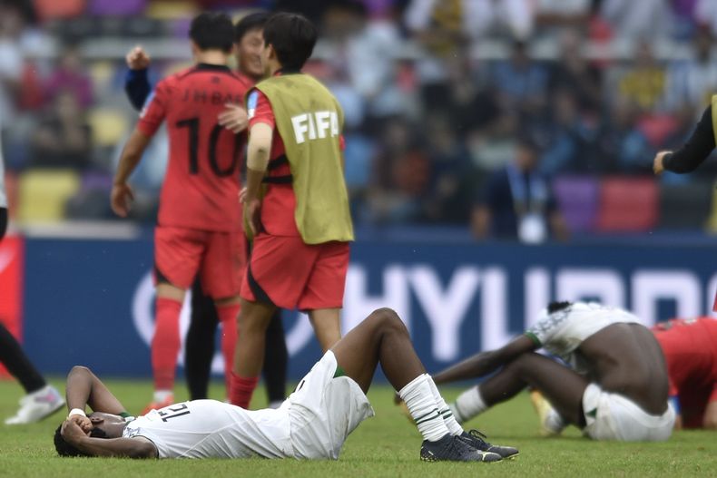 El nigeriano Benjamin Fredrick aparece tirado en la cancha tras la derrota 1-0 ante Corea del Sur en los cuartos de final del Mundial Sub20, el domingo 4 de junio de 2023, en Santiago del Estero, Argentina. (AP Foto/Gustavo Garello)