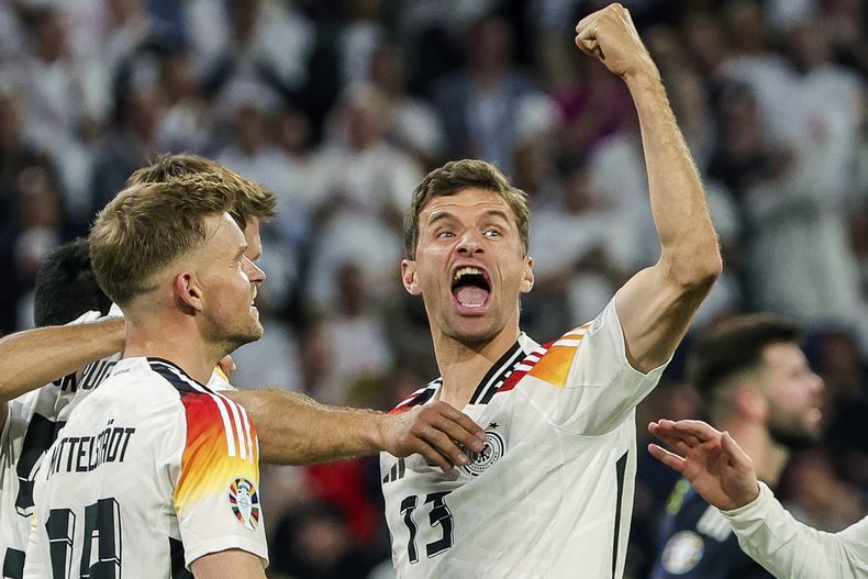 ARCHIVO - El alemán Thomas Müller, a la derecha, celebra durante el partido del Grupo A entre Alemania y Escocia en la Eurocopa 2024 en Múnich, Alemania, el viernes 14 de junio de 2024. Müller anunció su retiro del fútbol internacional después de una carrera de 14 años que incluyó el título de la Copa del Mundo de 2014. (Christian Charisius/dpa vía AP, Archivo)