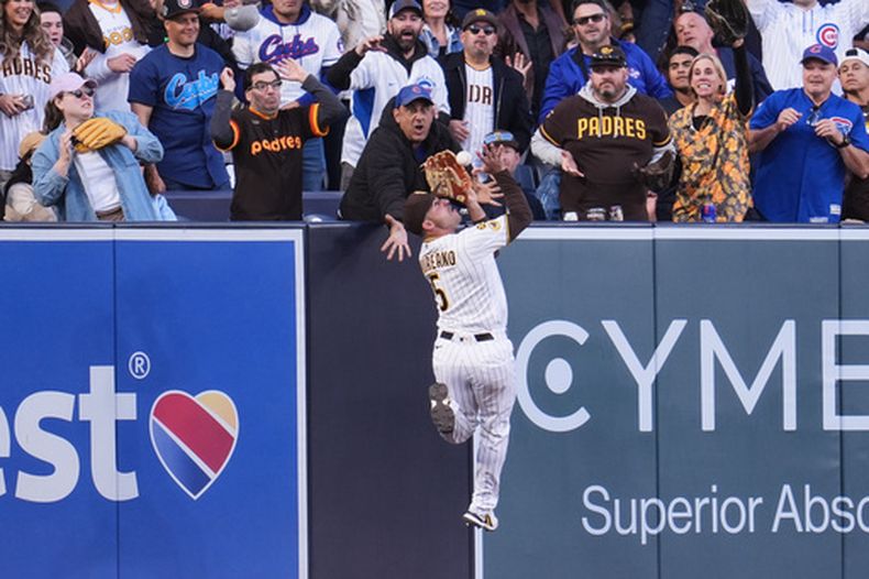Ramon Laureano, de los Padres de San Diego, hace una atrapada cerca de la barda para retirar a Alex Bregman, de los Cachorros de Chicago, durante la primera entrada del juego de béisbol de Grandes Ligas, el lunes 27 de abril de 2026, en San Diego. (AP Foto/Gregory Bull)