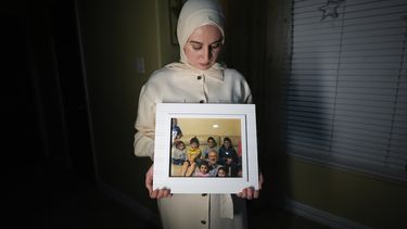 Maryam Kamalmaz muestra una fotografía de su padre con algunos de sus 14 nietos, en Grand Prairie, Texas, el 17 de enero de 2024. (AP Foto/Julio Cortez)