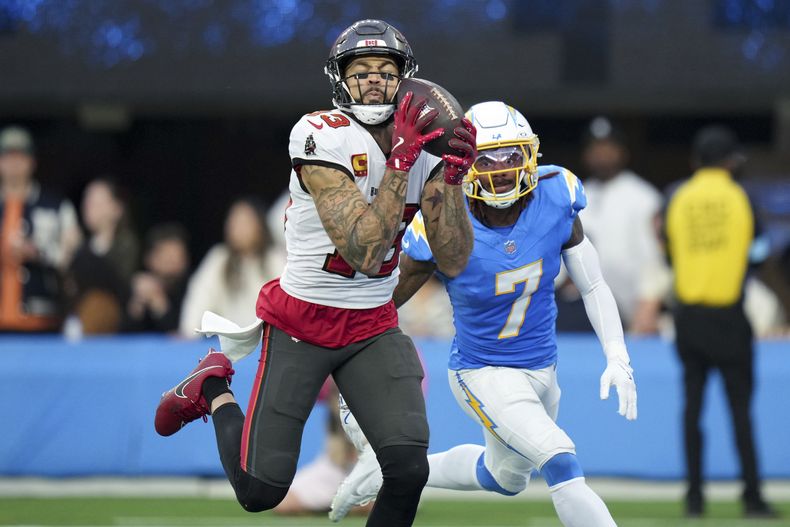El receptor abierto de los Buccaneers de Tampa Bay, Mike Evans, a la izquierda, atrapa un touchdown que supera al esquinero de los Chargers de Los Angeles, Kristian Fulton (7), en un partido de fútbol americano de la NFL, el domingo 15 de diciembre de 2024, en Inglewood, California. (AP Foto/Eric Thayer)
