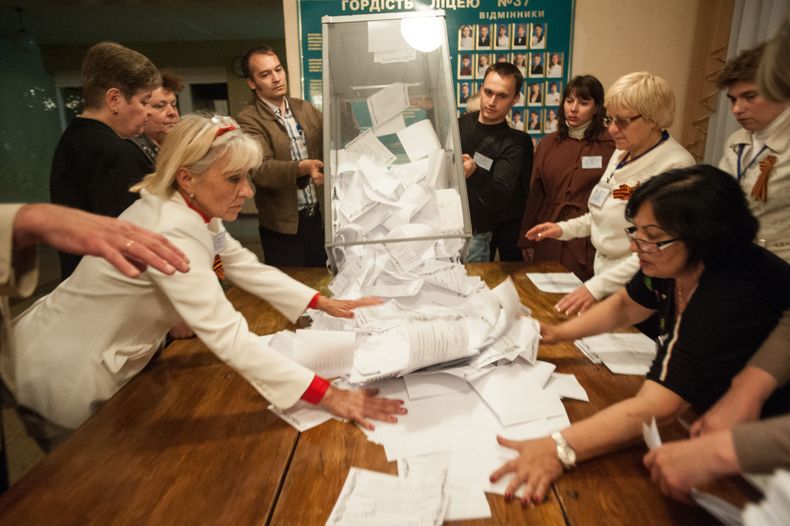 Integrantes de un comit&eacute; electoral vac&iacute;an una urna donde se depositaron votos en Donetsk, Ucrania, el domingo 11 de mayo de 2014. Votantes de dos regiones insurgentes ucranianas sufragaron el domingo para demandar mayor autonom&iacute;a de l