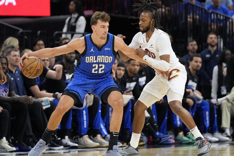 Franz Wagner (22) del Magic de Orlando con el balón ante Darius Garland de los Cavaliers de Cleveland en los playoffs de la NBA, el sábado 27 de abril de 2024, en Orlando. (AP Foto/John Raoux)