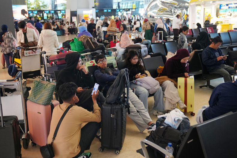 Gente espera durante interrupción en los vuelos debido a la erupción del monte Anak Krakatau, en el aeropuerto internacional de Tangerang, Indonesia, el lunes 7 de septiembre de 2026. (AP Foto/Tatan Syuflana)