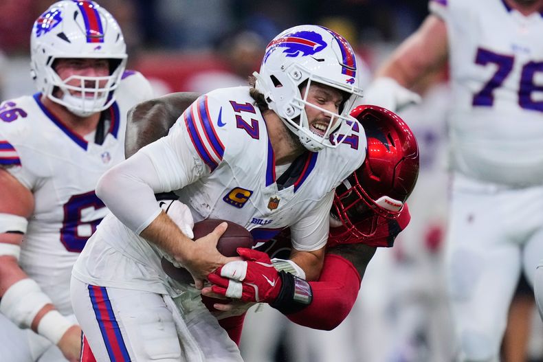 El quarterback de los Bills de Buffalo Josh Allen es capturado por el tacle defensivo de los Texans de Houston Mario Edwards Jr. en el encuentro del jueves 20 de noviembre del 2025. (AP Foto/Eric Christian Smith)