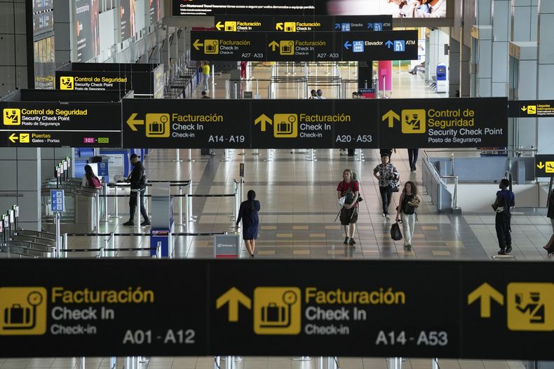Los viajeros caminan por el Aeropuerto Internacional de Tocumen en la Ciudad de Panamá, el jueves 22 de mayo de 2025, mientras Panamá y Venezuela se preparan para reanudar los vuelos comerciales. (AP Foto/Matías Delacroix)