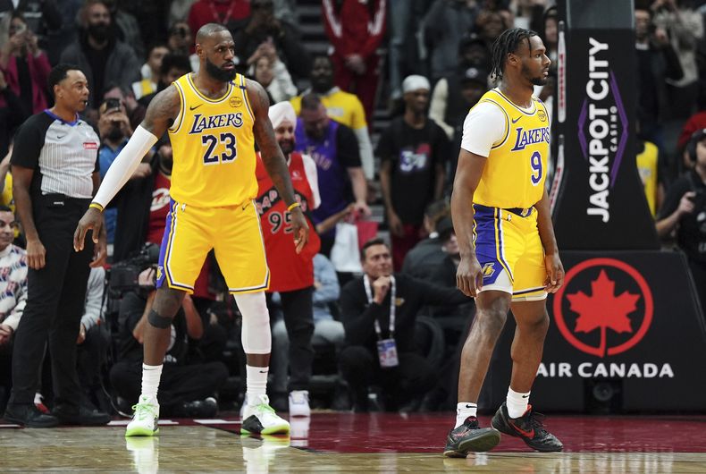 LeBron James (23) y su hijo Bronny, de los Lakers de Los Angeles, participan en el encuentro del viernes 1 de noviembre de 2024, ante los Raptors de Toronto (Frank Gunn/The Canadian Press via AP)