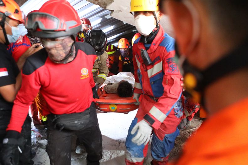 Rescatistas trasladan a un sobreviviente sacado de entre los escombros tras el derrumbe de un edificio en construcción en un internado islámico en Sidoarjo, en Java Oriental, Indonesia, el 1 de octubre de 2025. (AP Foto/Alam Syahirul)