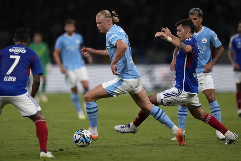 Erling Haaland (centro) del Manchester City se abre paso entre defensores del Yokohama F Marinos durante un partido amistoso en Tokio, el domingo 23 de julio de 2023. (AP Foto/Shuji Kajiyama)