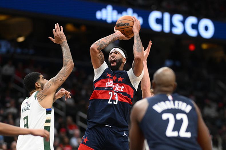 Anthony Davis (23), de los Wizards de Washington, se alza para encestar frente a Kelel Ware (9), de los Bucks de Milwaukee, durante la segunda mitad del juego de baloncesto de la NBA, el miércoles 21 de octubre de 2026, en Washington. (AP Foto/Nick Wass)