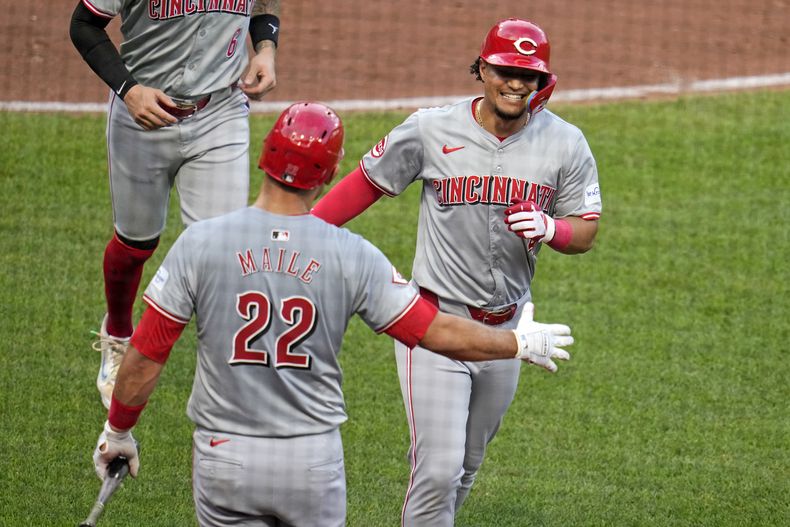 El dominicano de los Rojos de Cincinnati, Santiago Espinal (derecha) celebra con Luke Maile (22) mientras regresa al banquillo luego de conectar un jonrón de dos carreras ante el abridor de los Piratas de Pittsburgh, Bailey Falter, durante la quinta entrada del juego de béisbol en Pittsburgh, el martes 18 de junio de 2024. (AP Foto/Gene J. Puskar)