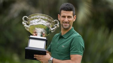 ARCHIVO - Foto del 30 de enero del 2023, el serbio Novak Djokovic sostiene el trofeo tras ganar el Abierto de Australia al superar al griego Stefanos Tsitisipas. El sábado 27 de mayo del 2023, Djokovic se prepara para ganar su 23mo título de Grand Slam en el Abierto de Francia, que no contará con Rafael Nadal. (AP Foto/Mark Baker, Archivo)