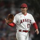 El japonés Shohei Ohtani habla con el intérprete Ippei Mizuhara al abandonar el montículo en la sexta entrada del juego ante los Astros de Houston, e viernes 14 de julio de 2023 (AP Foto/Ashley Landis)