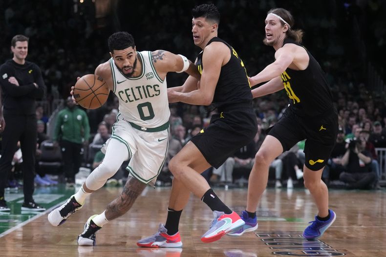 Jayson Tatum, de los Celtics de Boston, se desmarca de Simone Fontecchio, del Jazz de Utah, en el partido del viernes 5 de enero de 2024 (AP Foto/Charles Krupa)