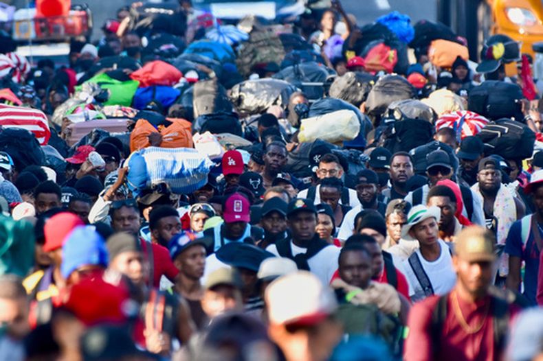 Migrantes caminan por la carretera que atraviesa el municipio de Huehuetán, estado de Chiapas, México, el martes 21 de abril de 2026, tras haber salido de Tapachula la noche anterior. (Foto AP/Edgar H. Clemente)