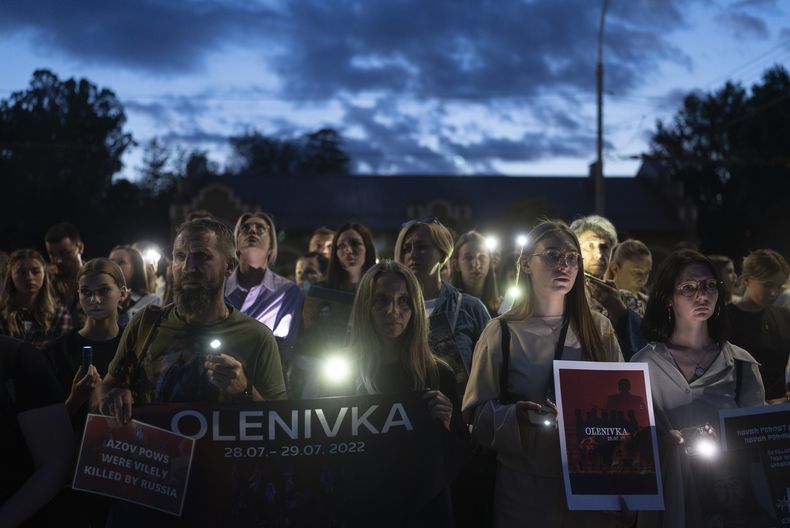 Gente sostiene carteles ante la embajada rusa en Kiev, Ucrania, el sábado 29 de julio de 2023, en el primer aniversario del ataque a una edificio penitenciario en Olenivka, en el este de Ucrania, en el que murieron docenas de prisioneros militares ucranianos. (AP Foto/Jae C. Hong)