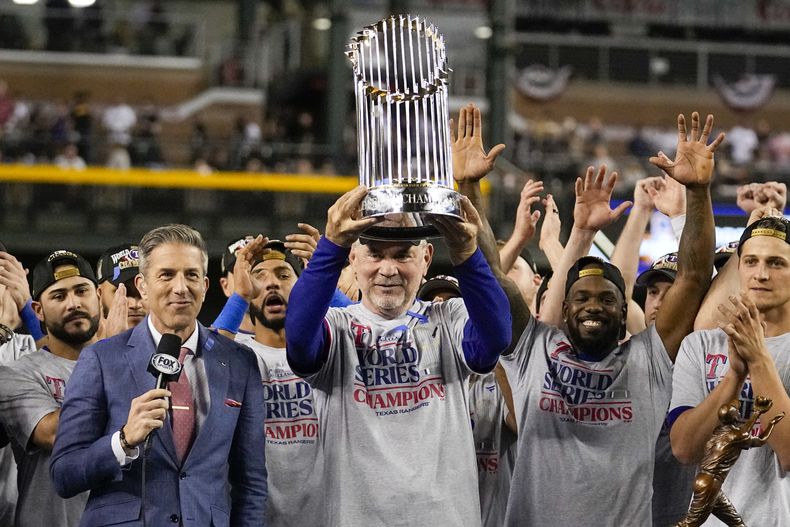 Bruce Bochy, manager de los Rangers de Texas, alza el trofeo de campeón después del Juego 5 de la Serie Mundial de béisbol, luego de vencer a los Diamondbacks de Arizona, el miércoles 1 de noviembre de 2023, en Phoenix. Los Rangers ganaron 5-0 para ganar la serie 4-1. (AP Foto/Brynn Anderson)
