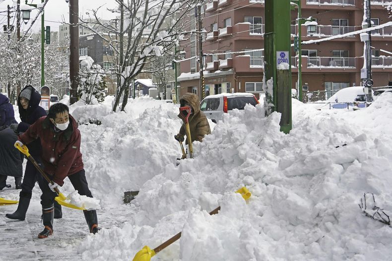 Gente retira nieve de una calle en Kushiro, Hokkaido, Japón, el martes 4 de febrero de 2025. (Kyodo News via AP)