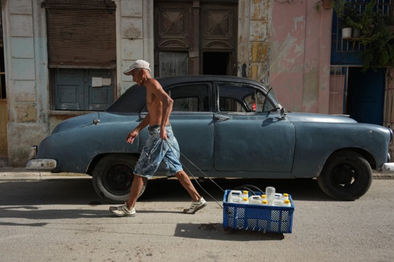 Un hombre tira de un carrito que transporta agua potable durante un apagón en La Habana, Cuba, el lunes 3 de agosto de 2026. (AP Foto/Ramón Espinosa)