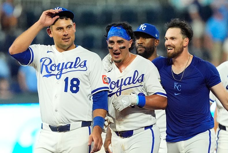 Nick Loftin (derecha), de los Reales de Kansas City, celebra con Josh Rojas (centro) después de conectar un toque de bola para un sencillo que impulsó a Rojas con la carrera del triunfo en la novena entrada de un partido de béisbol contra los Gigantes de San Francisco, el lunes 20 de julio de 2026, en Kansas City, Misuri. (Foto AP/Charlie Riedel)