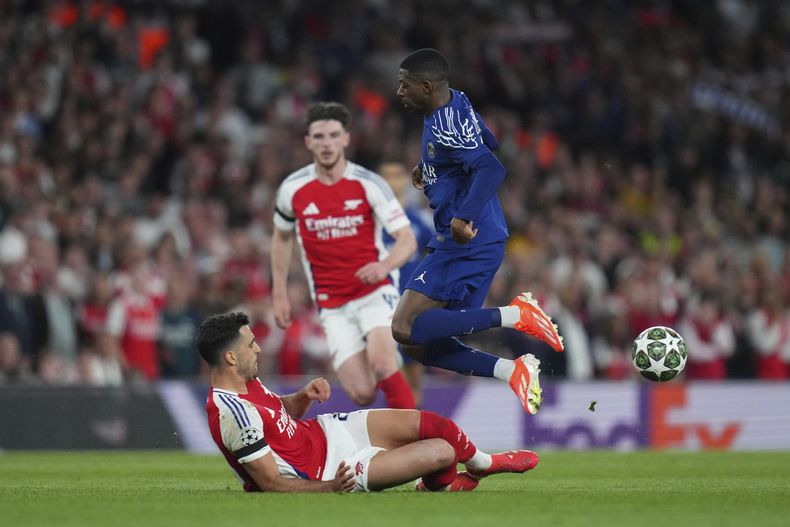Ousmane Dembele (derecha) del Paris Saint-Germain salta sobre Mikel Merino de Arsenal en la ida de las semifinales de la Liga de Campeones, el martes 29 de abril de 2025, en Londres. (AP Foto/Kirsty Wigglesworth)
