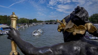 Una barcaza surca por el río Sena frente al puente Alexandre III durante los Juegos Olímpicos de París, el domingo 28 de julio de 2024. (AP Foto/Yasin Dar)