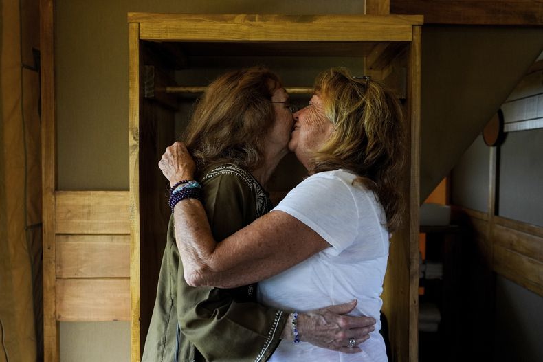 Ellen Shelburne, izquierda, y Beverly Cookie Grant se abrazan dentro de su carpa de campamento de lujo en el Centro para las Artes Bethel Woods, sede de la Feria de Arte y Música de Woodstock, el viernes 14 de junio de 2024, en Bethel, Nueva York. (Foto AP/Julia Nikhinson)