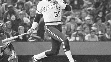 ARCHIVO - Dave Parker, de los Piratas, observa el recorrido de la pelota después de conectar un batazo que botó de forma extraña frente a Rich Dauer, de los Orioles, y se escurrió hasta el jardín derecho, impulsando a Omar Moreno con la primera carrera en la séptima entrada del sexto juego de la Serie Mundial, el 16 de octubre de 1979, en Baltimore. A Parker se le acreditó un sencillo. (AP Foto, Archivo)