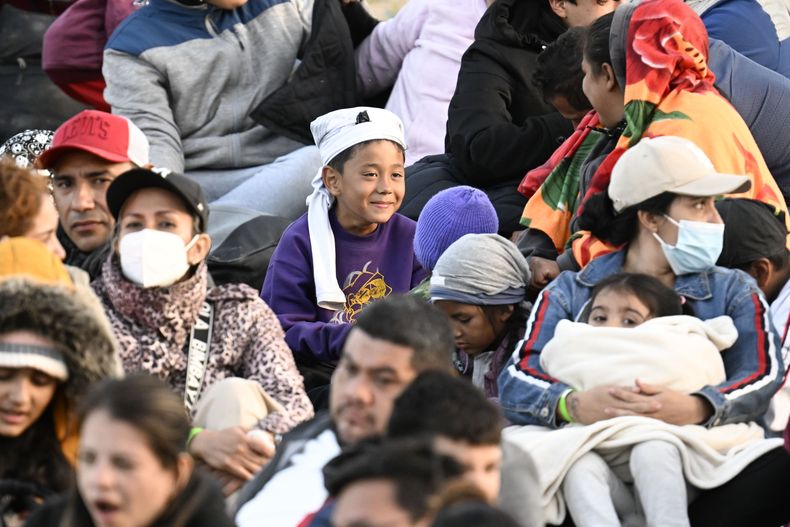 Solicitantes de asilo esperan entre dos muros fronterizos sobre territorio estadounidense a lo largo de la frontera con México, cerca de Tijuana, el lunes 8 de mayo de 2023, en San Diego. Los migrantes aguardan a ser procesados por la Patrulla Fronteriza. (AP Foto/Denis Poroy)