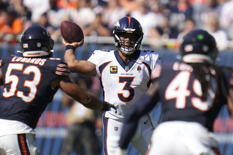 El quarterback de los Broncos de Denver Russell Willson lanza un pase, mientras defiende T.J. Edwards (53) liniero de los Bears de Chicago durante la 2da mitad del juego en Chicago. Domingo 1 de octubre de 2023. (AP Foto/Erin Hooley)