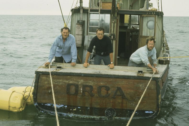 Esta imagen publicada por Peacock muestra, de izquierda a derecha, a Robert Shaw, Roy Scheider y Richard Dreyfuss en una escena de Jaws. (Peacock/Universal Pictures via AP)
