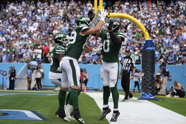 El running back de los Jets de Nueva York, Braelon Allen (0), celebra anotar un touchdown con su compañero de equipo, el tight end tight end de los Jets, Jeremy Ruckert (89), en la segunda mitad en Nashville, Tennessee, el domingo 15 de septiembre de 2024. (AP Foto/George Walker IV)
