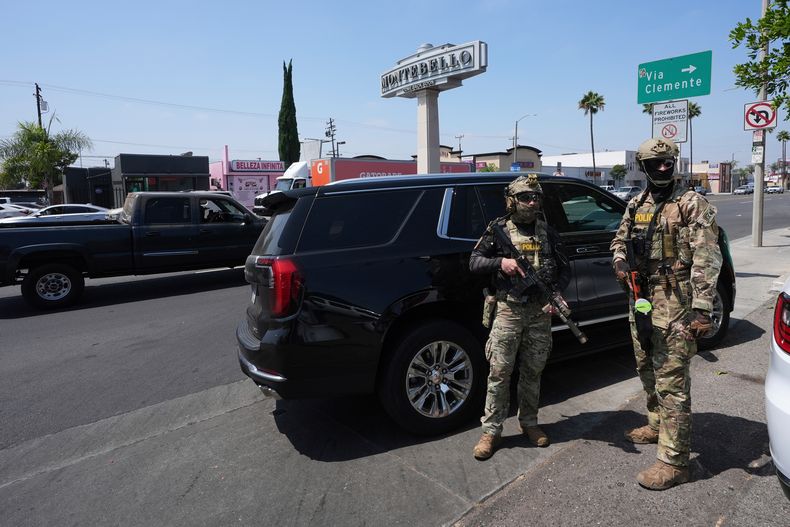 ARCHIVO – Agentes de inmigración realizan una operación en un negocio de lavado de autos, el 15 de agosto de 2025, en Montebello, California. (AP Foto/Gregory Bull, Archivo)