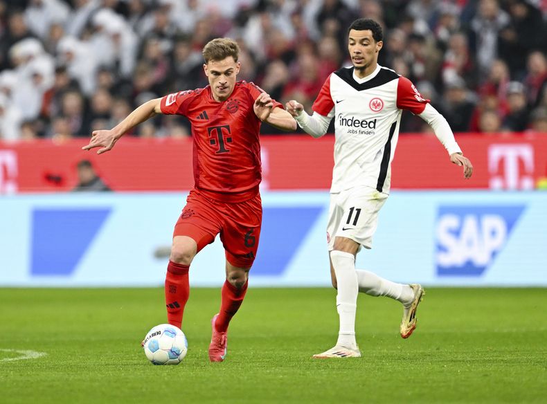 Joshua Kimmich (6) del Bayern Múnich y Hugo Ekitike (11) de Eintracht Frankfurt pugnan por el balón en el partido de la Bundesliga, el domingo 23 de febrero de 2025, en Múnich. (Sven Hoppe/dpa vía AP)