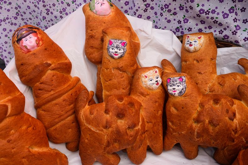 Tantawawas, panes tradicionales con forma de cholitas y gatos que se ofrecen a los difuntos en el Día de Muertos, se exhiben para su venta en un mercado callejero de La Paz, Bolivia, el jueves 30 de octubre de 2025. (Foto AP/Juan Karita)