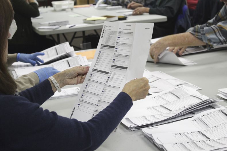 ARCHIVO - Un trabajador electoral examina una papeleta en la oficina electoral del condado de Clackamas el 19 de mayo de 2022, en Oregon City, Oregón. (AP Foto/Gillian Flaccus, Archivo)
