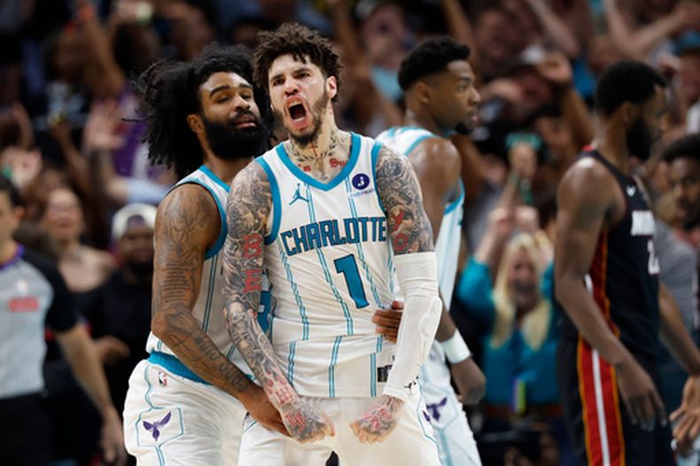 LaMelo Ball (1), base de los Hornets de Charlotte, celebra con Coby White tras anotar contra el Heat de Miami durante la segunda mitad de un juego de baloncesto del torneo play-in de la NBA en Charlotte, Carolina del Norte, el martes 14 de abril de 2026. (Foto AP/Nell Redmond)