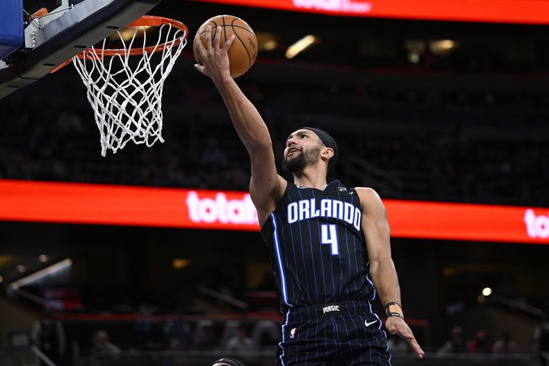 El base del Magic de Orlando Jalen Suggs salta para clavar el balón en el encuentro ante los Hornets de Charlotte el martes 19 de marzo del 2024. (AP Foto/Phelan M. Ebenhack)
