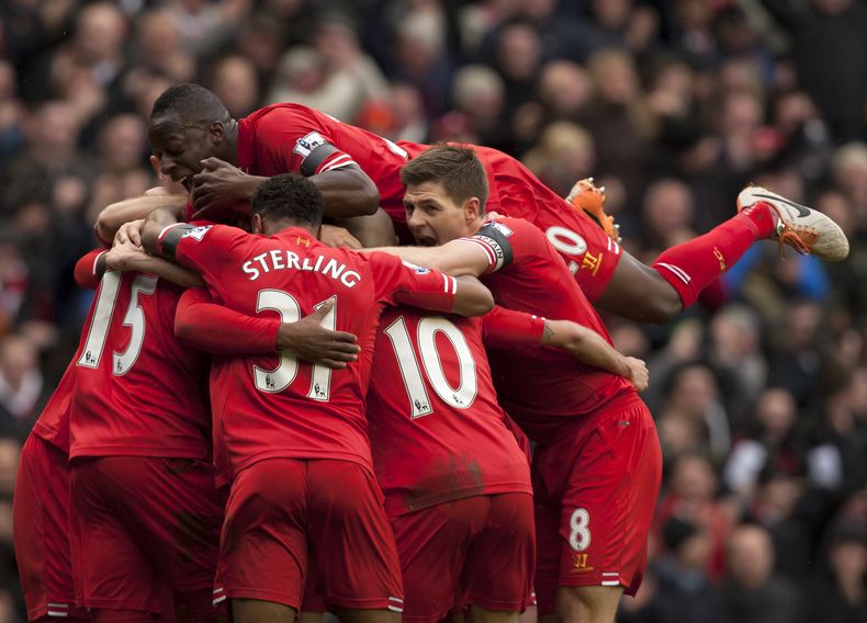 El jugador de Liverpool, Daniel Sturridge, tapado por sus compa&ntilde;eros, festeja un gol contra Arsenal en la liga Premier el s&aacute;bado, 8 de febrero de 2014, en Liverpool, Inglaterra. (AP Photo/Jon Super)