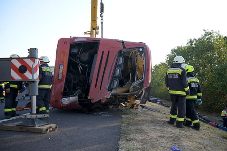 Trabajadores de emergencias asisten al lugar después de que un autobús de pasajeros se saliera de la carretera y volcara en una cuneta junto a una autopista entre Mezokeresztes y Mezonagymihaly en Hungría, el domingo 16 de agosto de 2026. (Zoltan Mathe/MTI via AP)