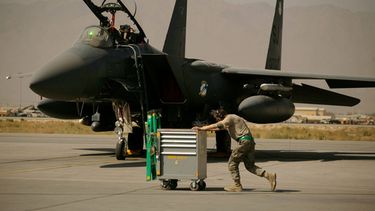 ARCHIVO - Un miembro de la Fuerza Aérea de Estados Unidos pasa empujando un carro por delante de un F-15E Strike Eagle en la Base Aérea de Bagram, en Afganistán, el 17 de octubre de 2009. (AP Foto/Maya Alleruzzo, archivo)
