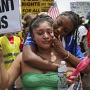 Daisy Morán, a la izquierda, y Constance Felton participan en una protesta contra las redadas del ICE y las detenciones para deportación, mientras la policía bloquea su marcha el sábado 14 de junio de 2025, en Chamblee Tucker Road, Atlanta. (Arvin Temkar/Atlanta Journal-Constitution vía AP)