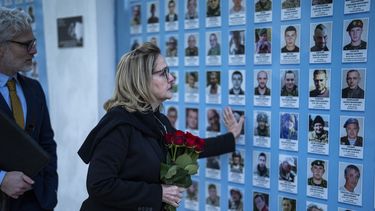 La congresista estadounidense, Madeleine Deane, demócrata por Pensilvania, coloca flores en un muro conmemorativo para los soldados ucranianos muertos durante la guerra en la catedral de San Miguel en Kiev, Ucrania, el lunes 22 de abril de 2024. (Foto AP/Francisco Seco)