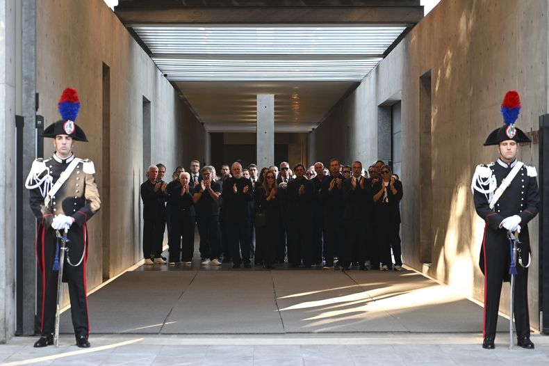 El personal de Giorgio Armani Spa se reúne afuera del Armani/Teatro en Milán, en el norte de Italia, mientras el coche fúnebre con el ataúd del diseñador Giorgio Armani, quien murió el jueves a los 91 años, parte el domingo 7 de septiembre de 2025. (Foto AP/Nicola Marfisi)