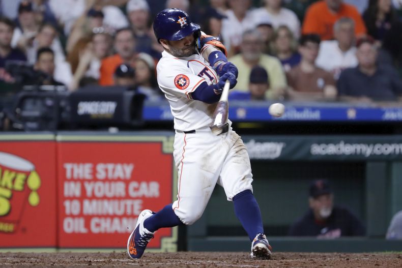 El venezolano José Altuve, de los Astros de Houston, pega un sencillo productor en el juego del jueves 2 de mayo de 2024, ante los Guardianes de Cleveland (AP Foto/Michael Wyke)