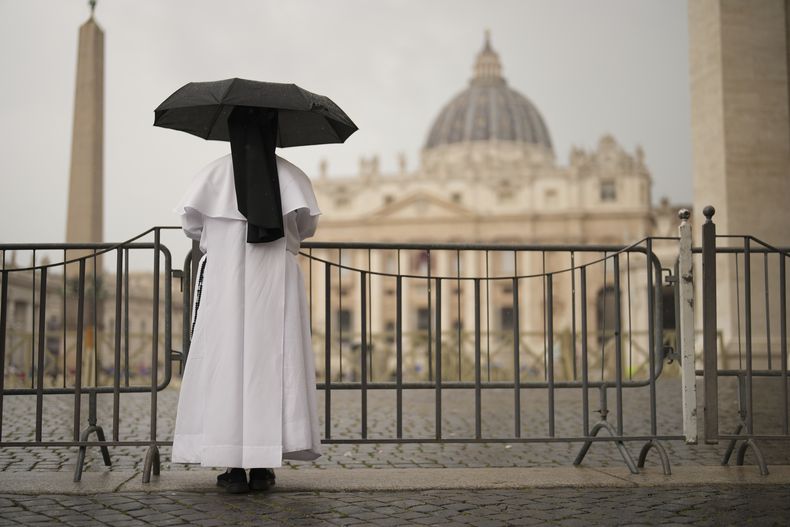 Una monja se resguarda de la lluvia mientras sigue la última misa en la Basílica de San Pedro de los cardenales que asisten al cónclave, en la Plaza de San Pedro del Vaticano, el 7 de mayo de 2025. (AP Foto/Francisco Seco)