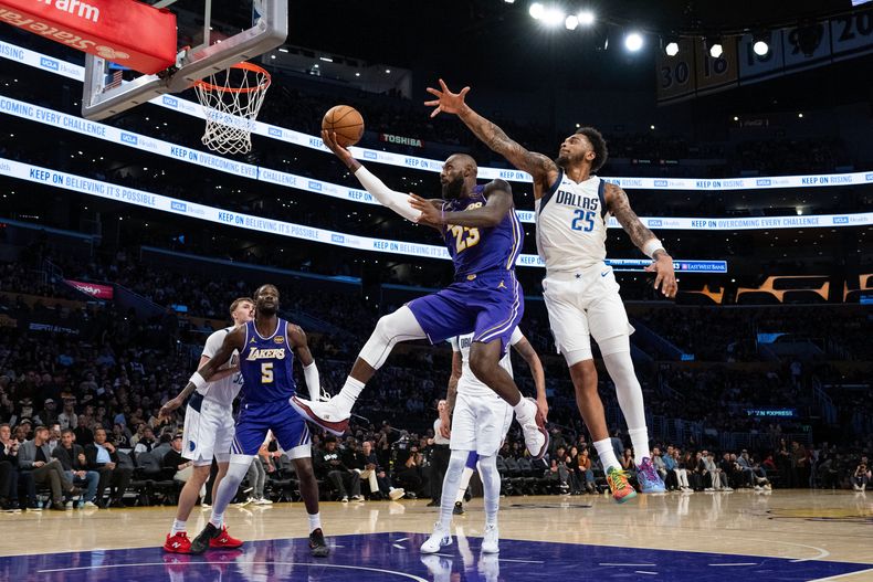 LeBron James, alero de los Lakers de Los Ángeles, salta para encestar frente a P.J. Washington, de los Mavericks de Dallas, el viernes 28 de noviembre de 2025 (AP Foto/Kyusung Gong)