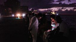 Gente pasa la noche en la oscuridad en el Malecón durante un apagón en La Habana, Cuba, el sábado 21 de marzo 2026. (AP Foto/Ramón Espinosa)