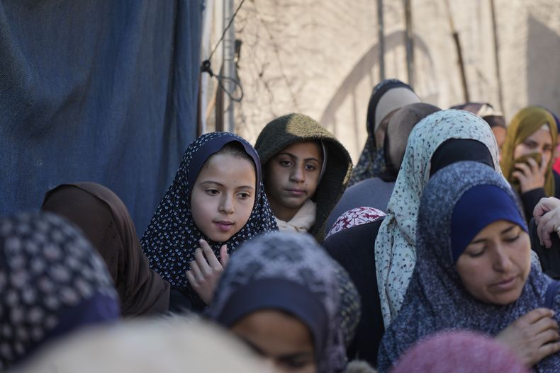 Palestinos se forman para recibir alimentos en la ciudad de Deir al-Balah, en la Franja de Gaza, el viernes 14 de febrero de 2025. (AP Foto/Abdel Kareem Hana)