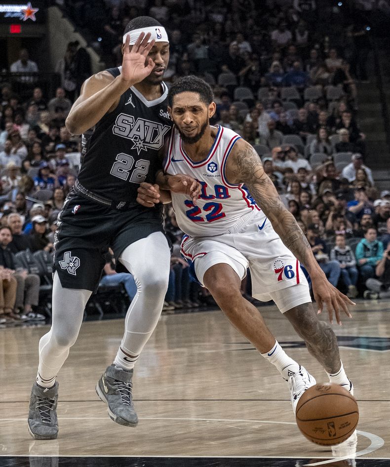 El escolta de los 76ers de Filadelfia, Cameron Payne, a la derecha, conduce hacia la canasta contra el escolta de los Spurs de San Antonio, Malaki Branham, a la izquierda, durante la primera mitad de un partido de baloncesto de la NBA, el domingo 7 de abril de 2024, en San Antonio. (AP Foto/Rodolfo González)